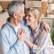 high angle view of happy senior couple embracing, holding hands and smiling each other in new home